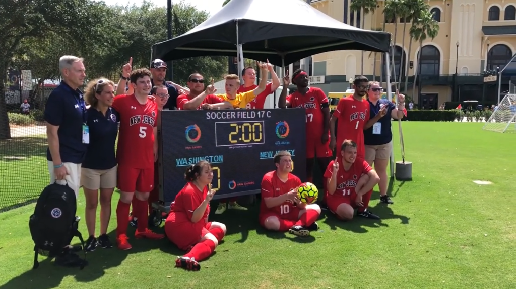 a group of people in red sports suits standing near the game score table on the field