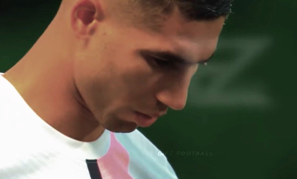 side view of Achraf Hakimi in a white t-shirt looking down